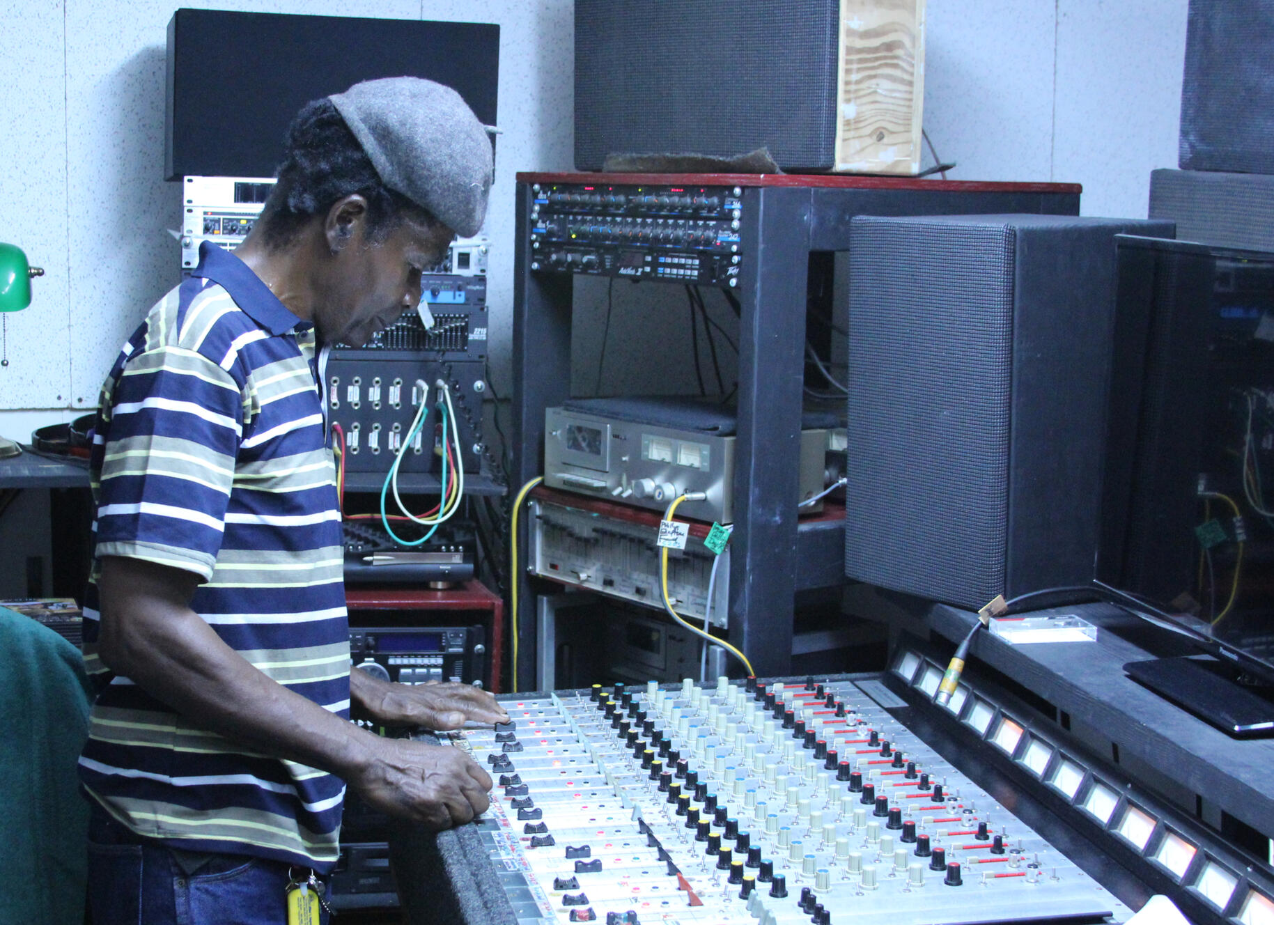 Jamaican Audio Engineer in Kingston Jamaican sound man or audio engineer Glen Whitter in his Kingston studio at the helm of a 1970s mixing console. Photograph by Daniel Piper, Public Educator